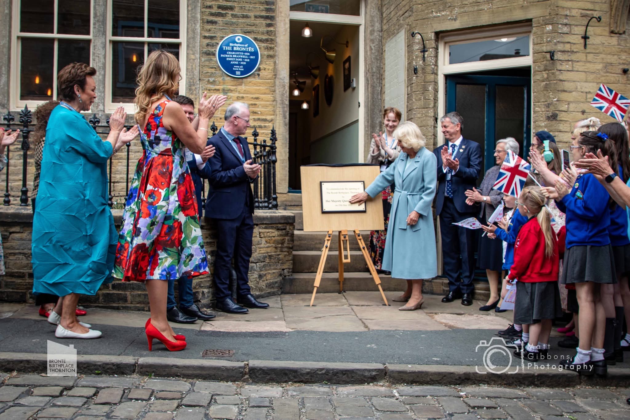 Queen Camilla unveiling plaque with onlookers watching